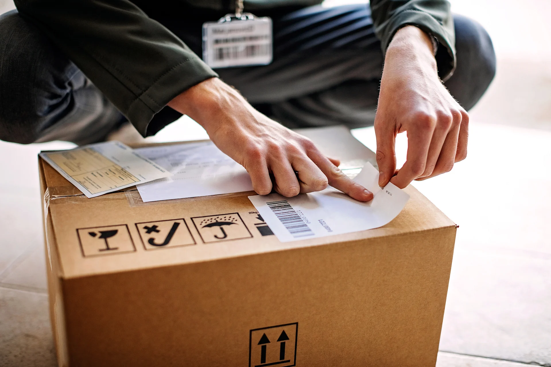 Person attaching shipping label to parcel