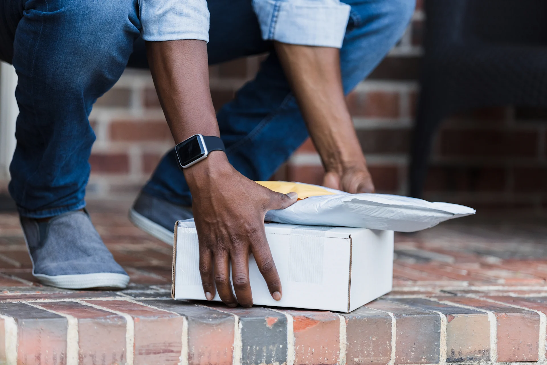 Man picking up parcel from ground