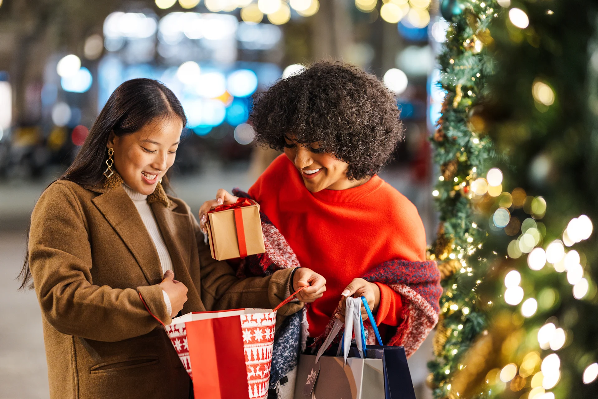 Two people packing Christmas gifts in carry bag