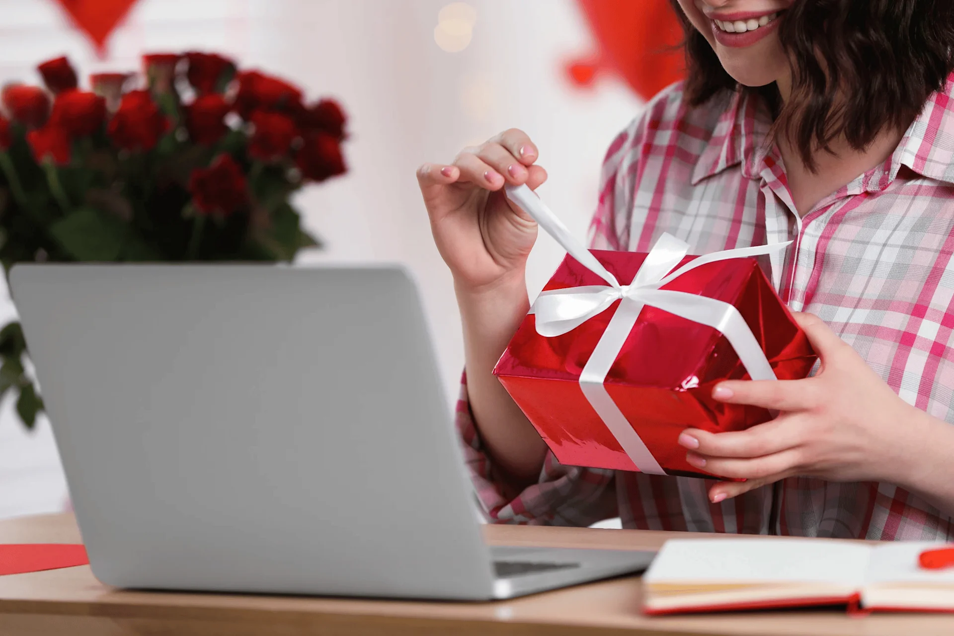 woman on laptop opening valentines gift